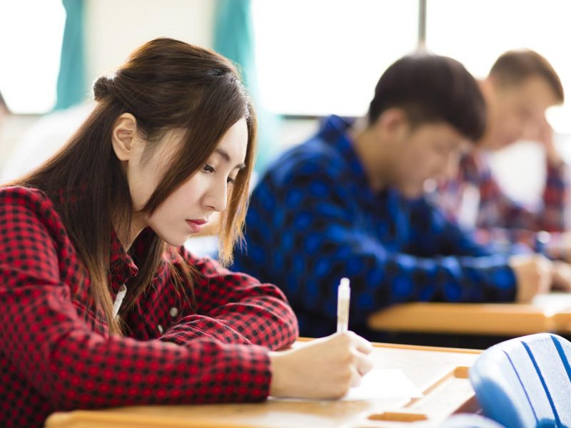 female college student sitting and exam in the classroom
